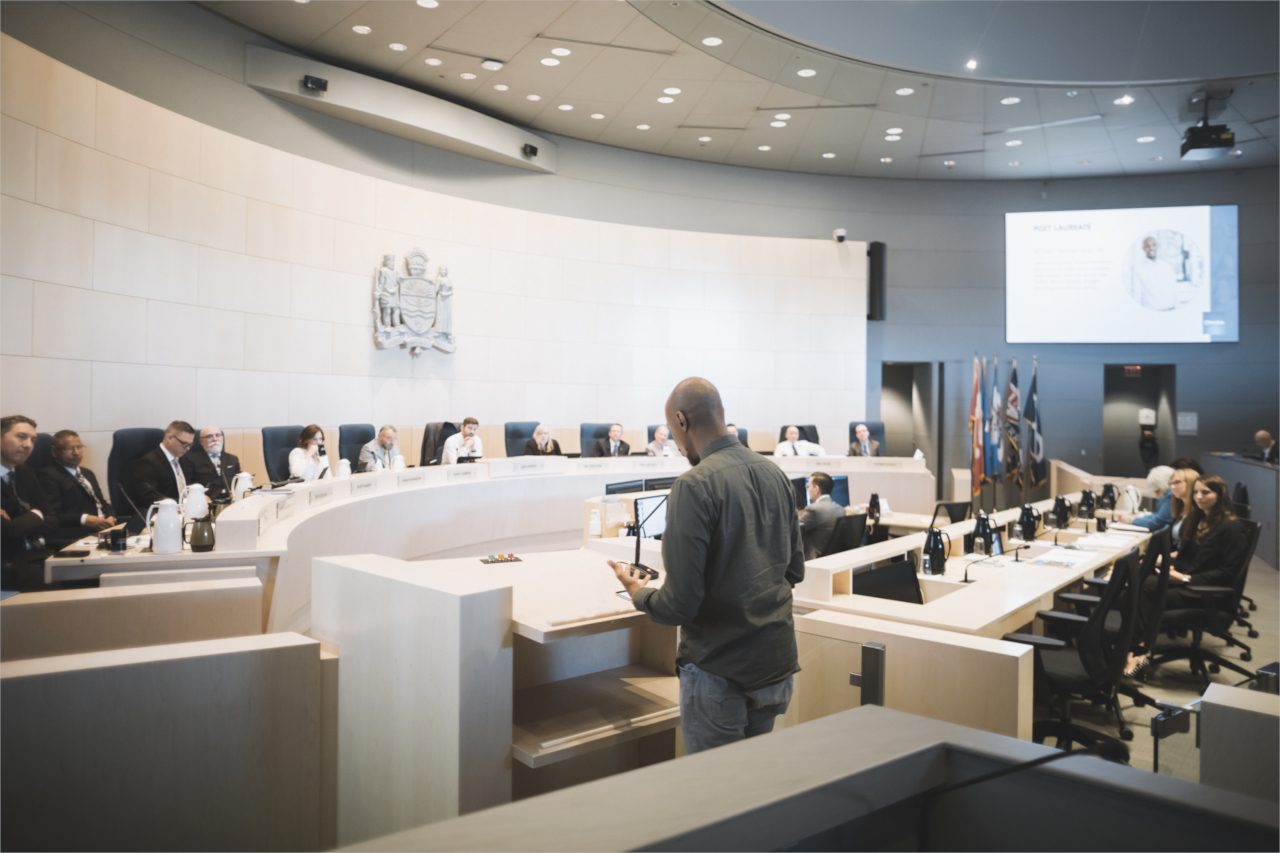 Ahmed Knowmadic Ali in Edmonton City Hall council chambers